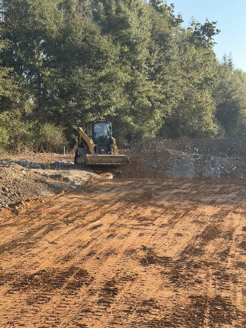 Tracked construction equipment beside the graded work area.